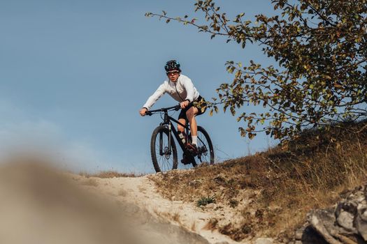 Equipped Professional Cyclist Descends a Slope on Mountain Bike, Sportsman Going Down from Hill on Bicycle