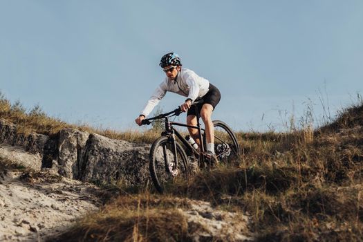 Equipped Professional Cyclist Descends a Slope on Mountain Bike, Sportsman Going Down from Hill on Bicycle