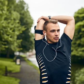 Hes got some serious determination. a sporty young man stretching before a run outdoors