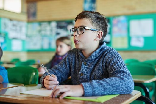 Education is the most powerful in shaping young minds. an elementary school boy working in class