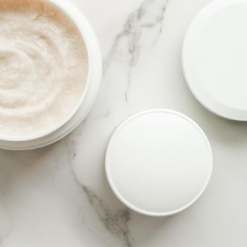 Scrub and exfoliating cream products on a marble, flatlay - skincare and body care, luxury spa and clean cosmetic concept. Health and beauty of your skin