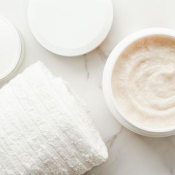 Scrub and exfoliating cream products on a marble, flatlay - skincare and body care, luxury spa and clean cosmetic concept. Health and beauty of your skin