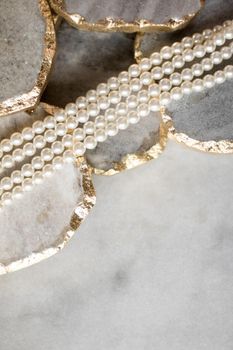Pearl necklace on golden marble, ethical jewellery - luxury background, jewelry as a gift concept. Pearls are girl's best friends