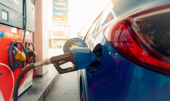 Car fueling at gas station. Refuel fill up with petrol gasoline. Petrol pump filling fuel nozzle in fuel tank of car at gas station. Petrol industry and service. Petrol price and oil crisis concept.