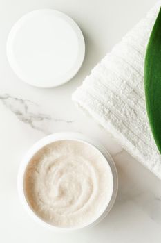 Scrub and exfoliating cream products on a marble, flatlay - skincare and body care, luxury spa and clean cosmetic concept. Health and beauty of your skin