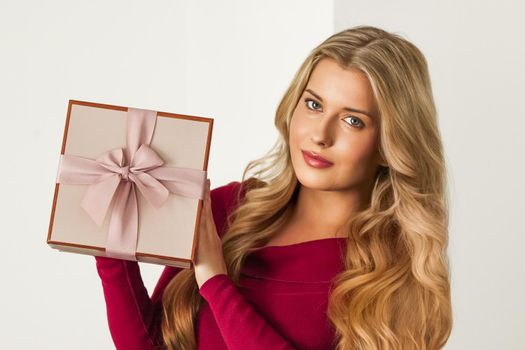 Happy woman holding a gift for birthday, anniversary, wedding, Valentines day or Christmas, luxury holiday present or beauty box subscription delivery concept