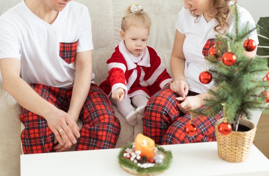 Toddler girl with cochlear implant having fun with her mother and father at home - holidays and hearing aid