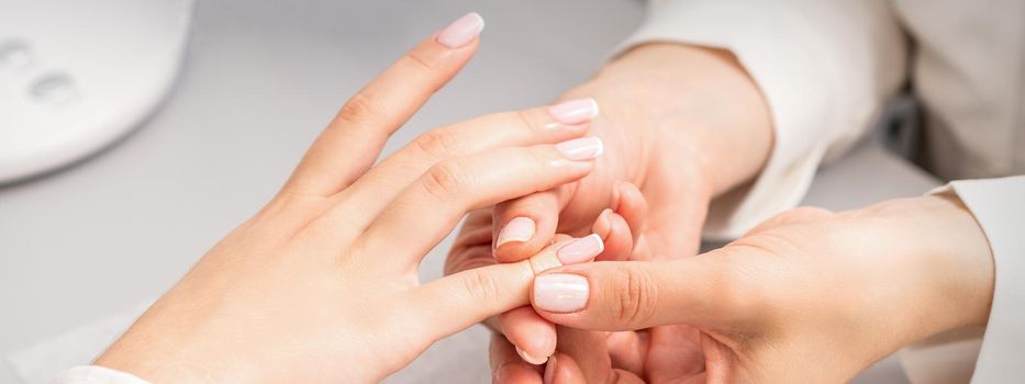 A woman's hand getting a finger massage in a nail salon. Manicure treatment at beauty spa