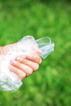 The person holds used crumpled plastic debris in his hand. Environmental problem concept.