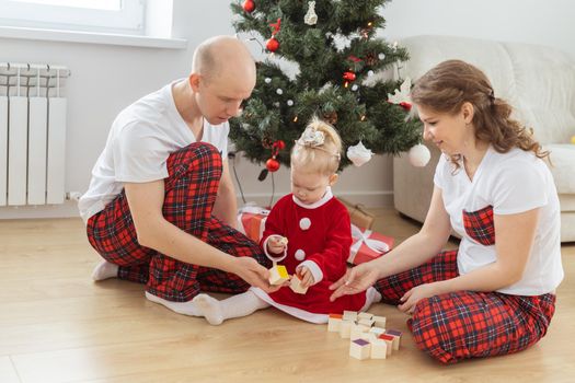 Baby child with hearing aid and cochlear implant having fun with parents in christmas room. Deaf and health