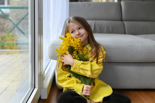 A girl holding mimosa on a white background