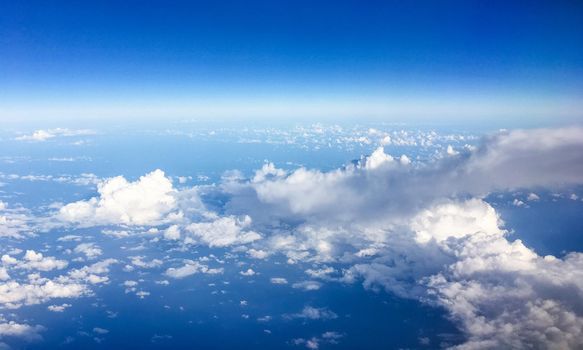 Travel, cloudscape and natural environment concept - View from the airplane window, sky and ocean blue