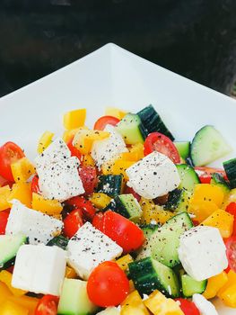 Fresh vegetable greek salad with cherry tomatoes, bell pepper, cucumber, feta cheese, olive oil and seasonal spices, healthy food diet and delicious meal recipe concept