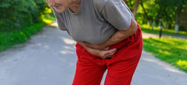 grandmother has a stomach ache on the road. Selective focus. people.