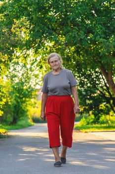 grandma is walking down the road. Selective focus. Nature.