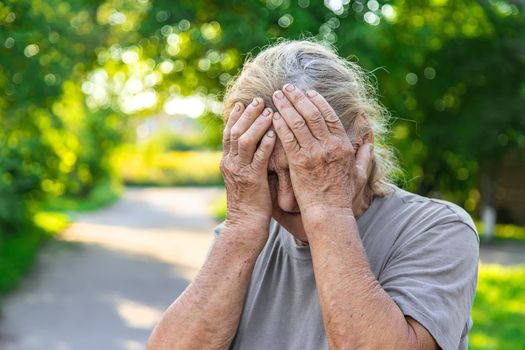 grandmother has a headache on the road. Selective focus. hurts