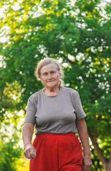 grandma is walking down the road. Selective focus. Nature.