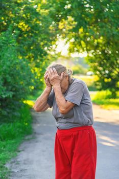 grandmother has a headache on the road. Selective focus. hurts