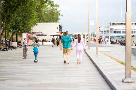 2022-07-17. Russia. Moscow. Northern River Station. Walk. A young couple walks hand in hand along the embankment on a summer day.