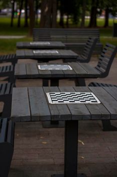 There are chess tables for everyone in the park. City playgrounds