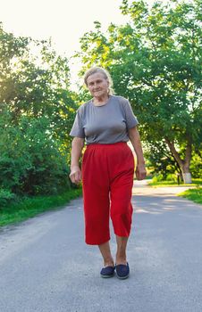 grandma is walking down the road. Selective focus. Nature.