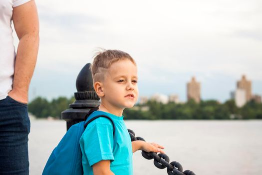 A boy in a blue T-shirt with a backpack on his back. Journey.  The face expresses natural joyful emotions. Not staged photos from nature.