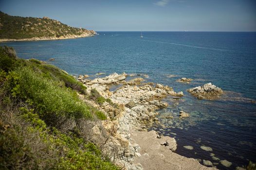 Natural inlet between the mountains and the sea in the south of Sardinia with the outline of a typical Mediterranean vegetation that grows spontaneously on the rocky walls.