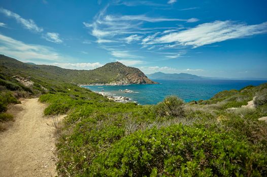 Panoramic view of a natural bay with the sea and the mountains and Mediterranean vegetation in southern Sardinia in Italy, specifically the beach of Cala Sa Figu