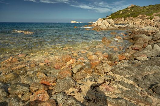 stones coming out of the sea where the sea meets the land at the shore.