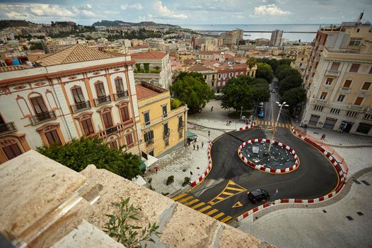 Top view of a portion of the historic center of Cagliari with a roundabout on the side and the historic buildings that surround it.