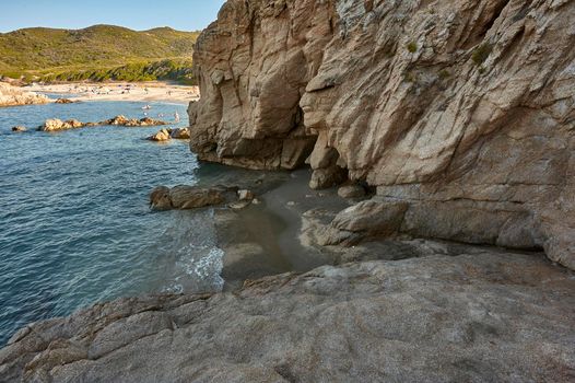 Natural cave carved on a rocky wall in the southern coast of Sardinia: Cala Sa Figu beach.