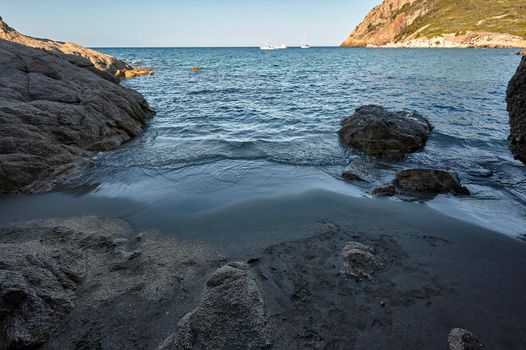 Hidden beach among the rocks at the exit of a natural cave in the south of Sardinia.