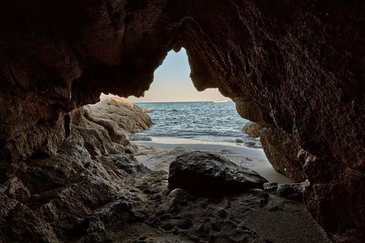 Rocky cave of a southern Sardinian beach overlooking the sea: a symbol of leaving your old being to cling to the new future.