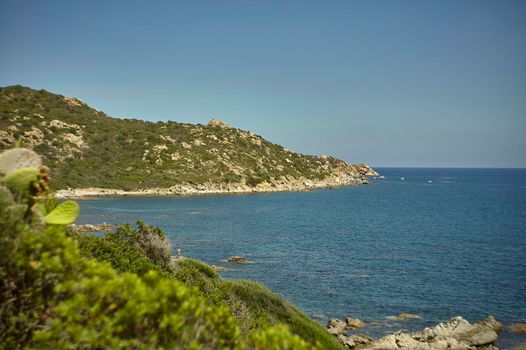 Natural inlet between the mountains and the sea in the south of Sardinia with the outline of a typical Mediterranean vegetation that grows spontaneously on the rocky walls.