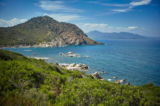 Natural inlet between the mountains and the sea in the south of Sardinia with the outline of a typical Mediterranean vegetation that grows spontaneously on the rocky walls.