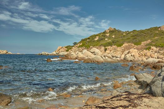 Detail of Cala Sa Figu beach in Sardinia with its typical rocks and hills rising above the sea.