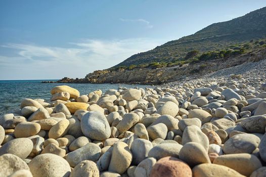 Pebbles belonging to a typical southern Sardinian beach in Italy with the background of the sea and of the whole of this marvelous natural and uncontaminated beach.