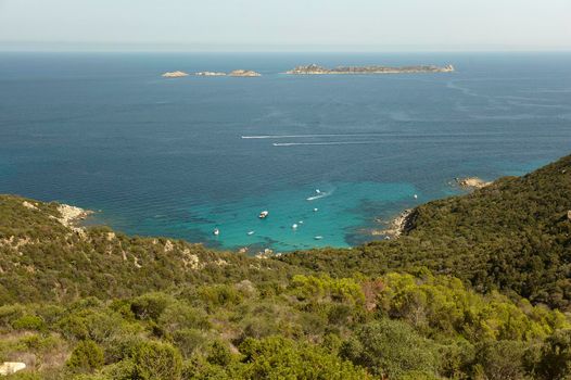 Top view of a portion of the coast facing the island of Serpentara in the south of Sardinia with some rubber boats used by tourists to visit this wonderful place.