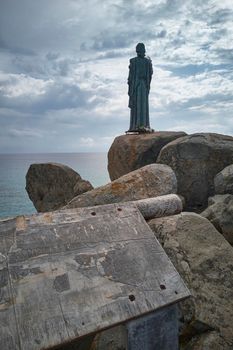 View of the Scoglio di Peppino in the south of Sardinia with its statue of Christ looking towards the sea.