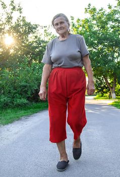 grandma is walking down the road. Selective focus. Nature.