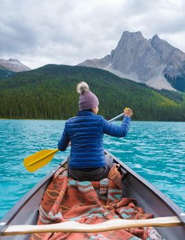 Emerald Lake in Autumn at the Yoho National Park Alberta Canada, men by the Emerald lake Canada. Asian women in canoe at the lake