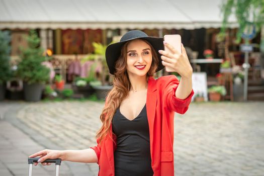 Beautiful young caucasian tourist woman takes a selfie in a European city