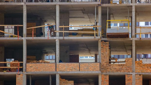 Skyscrapper building construction workers in different rooms. Workers divided by concrete walls.