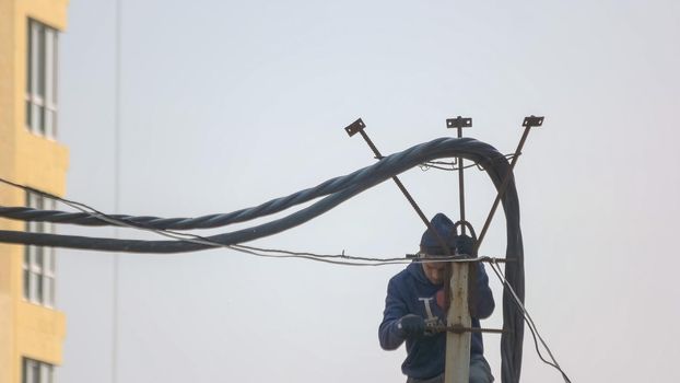 Kyiv,Ukraine - 24.04.2019: Technician men fixing or repairing broken power. Construction worker installing wires in a new building.