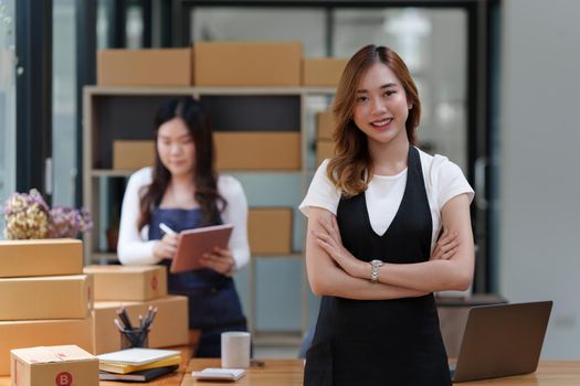 Asian SME business woman with partner working at home office. online shopping concept.