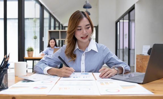 Asian woman working on a laptop computer,Working in the office with laptop concept,Young Asian woman starting a business using a laptop computer..