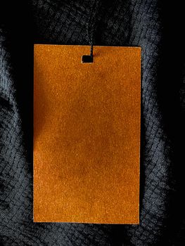 Blank fashion label tag, sale price card on luxury fabric background, shopping and retail concept