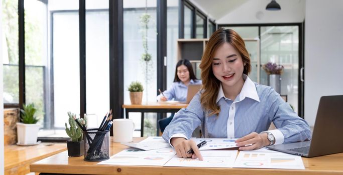 Asian woman working on a laptop computer,Working in the office with laptop concept,Young Asian woman starting a business using a laptop computer..