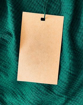 Blank fashion label tag, sale price card on luxury fabric background, shopping and retail concept