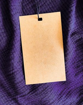 Blank fashion label tag, sale price card on luxury fabric background, shopping and retail concept